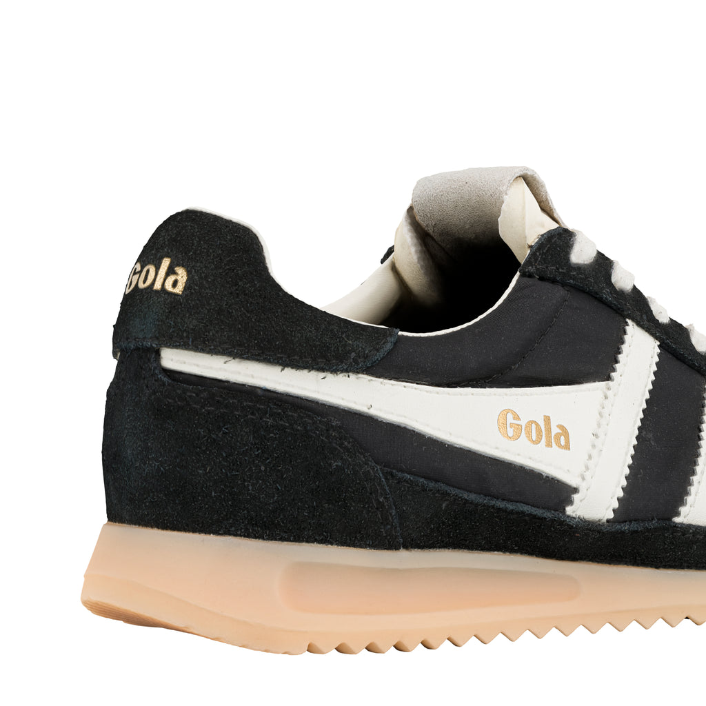 Close-up of the heel of a black Gola trainer with white stripes and a beige sole