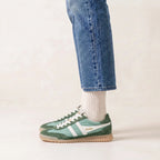 Gola Classics green and white trainers with gum sole worn with blue jeans and white socks