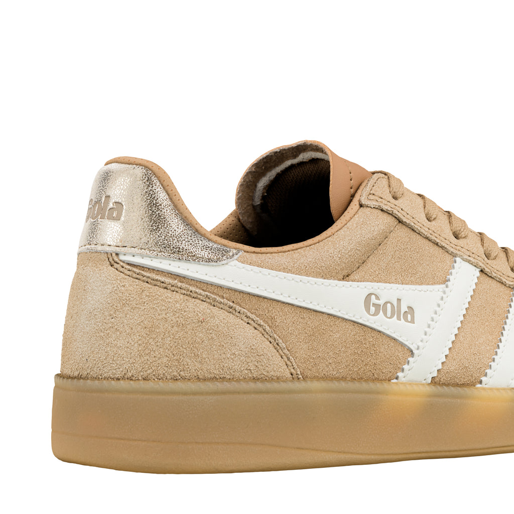 Close up of the heel and side of a beige suede Gola trainer with white trim and a metallic heel tab