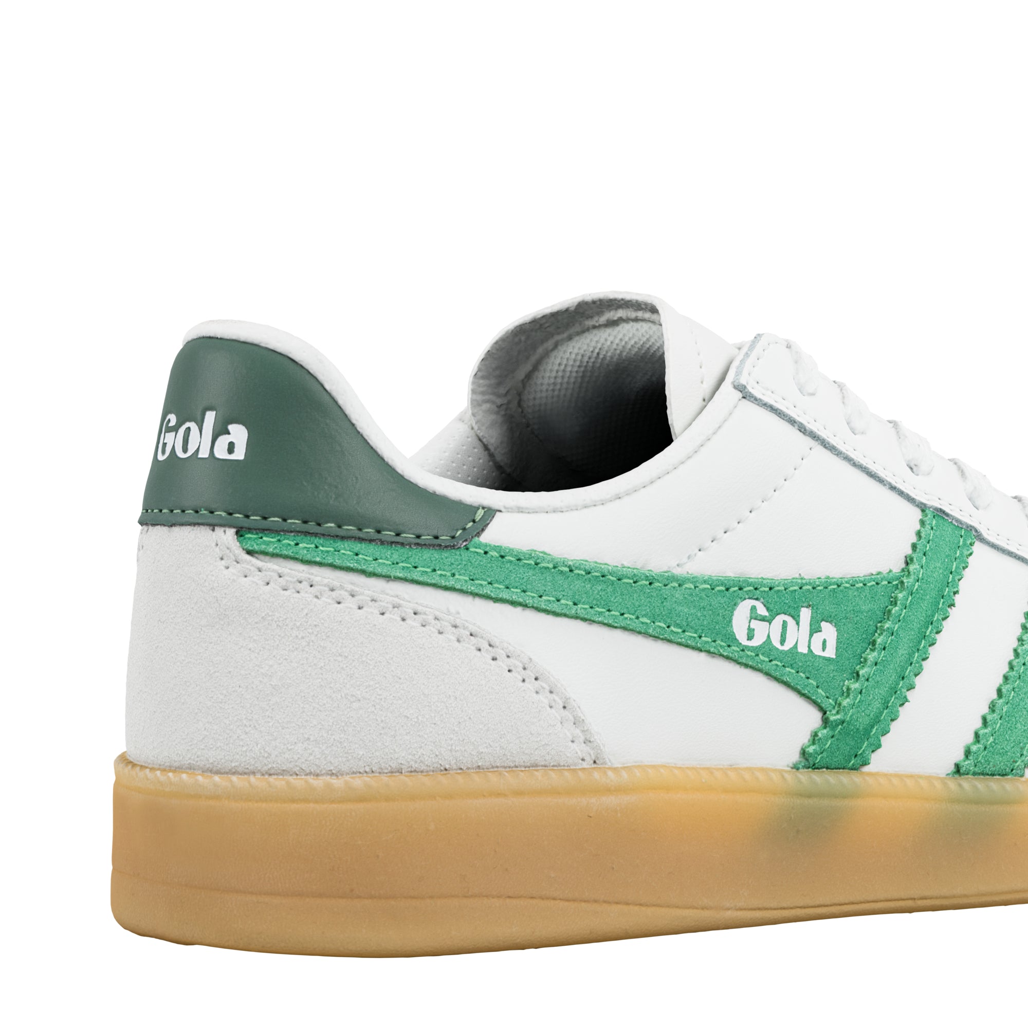 Close up of white Gola trainer with green suede detailing and gum sole