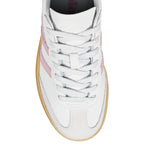 White trainer with pink side stripes and a gum sole