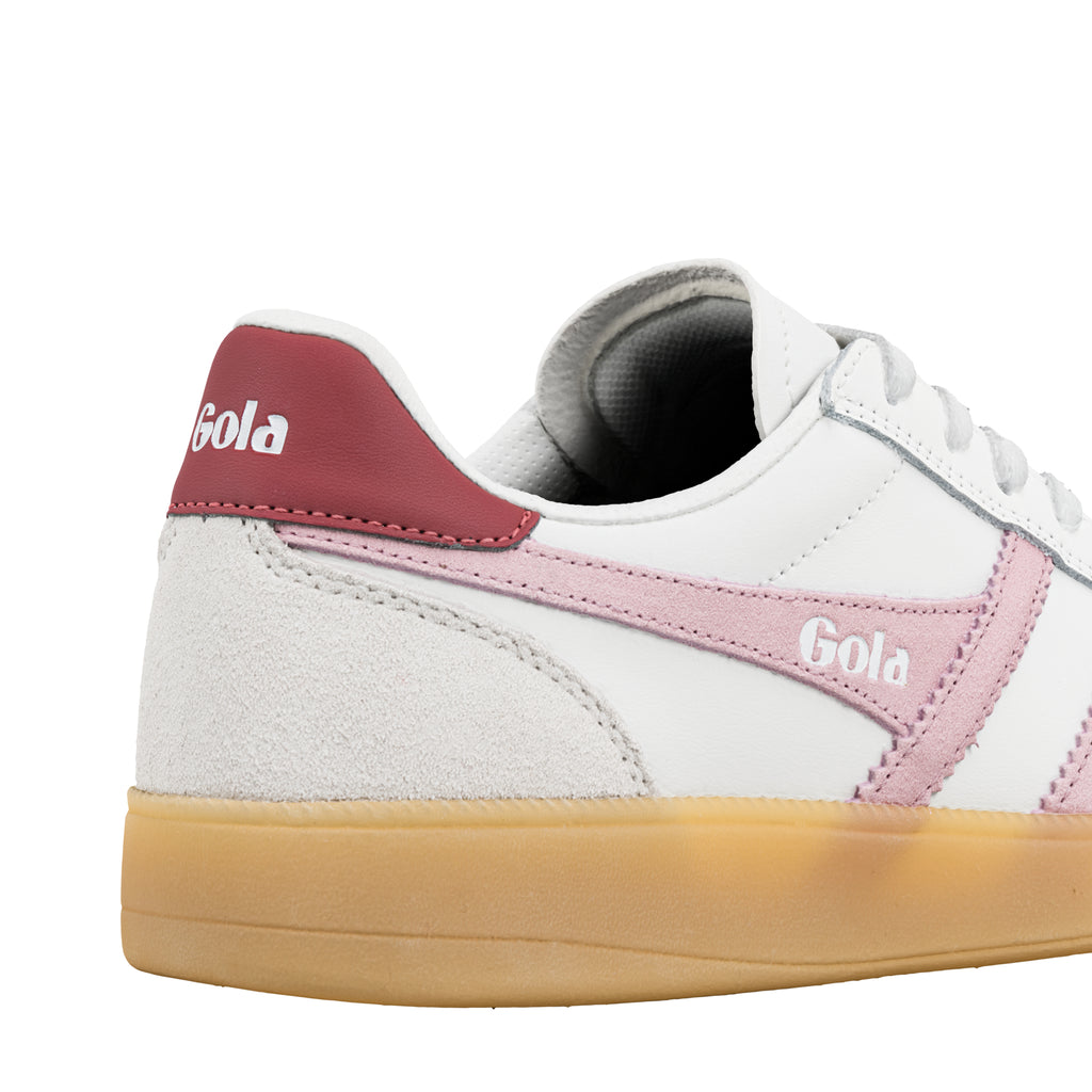 Close up of white trainer with pink side trim and gum sole