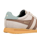 Close up of a beige suede Gola trainer with brown side stripes and a light blue heel tab