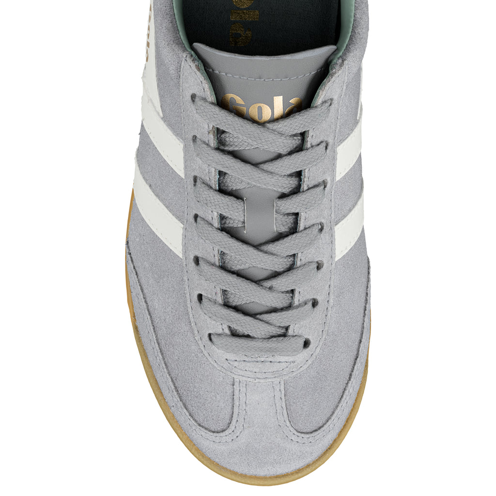 Top view of a grey suede trainer with white side stripes and a gum sole