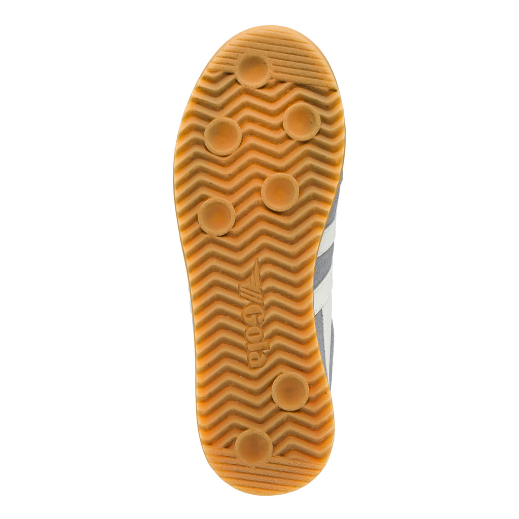Gum rubber trainer sole with a wavy tread pattern and circular grip studs