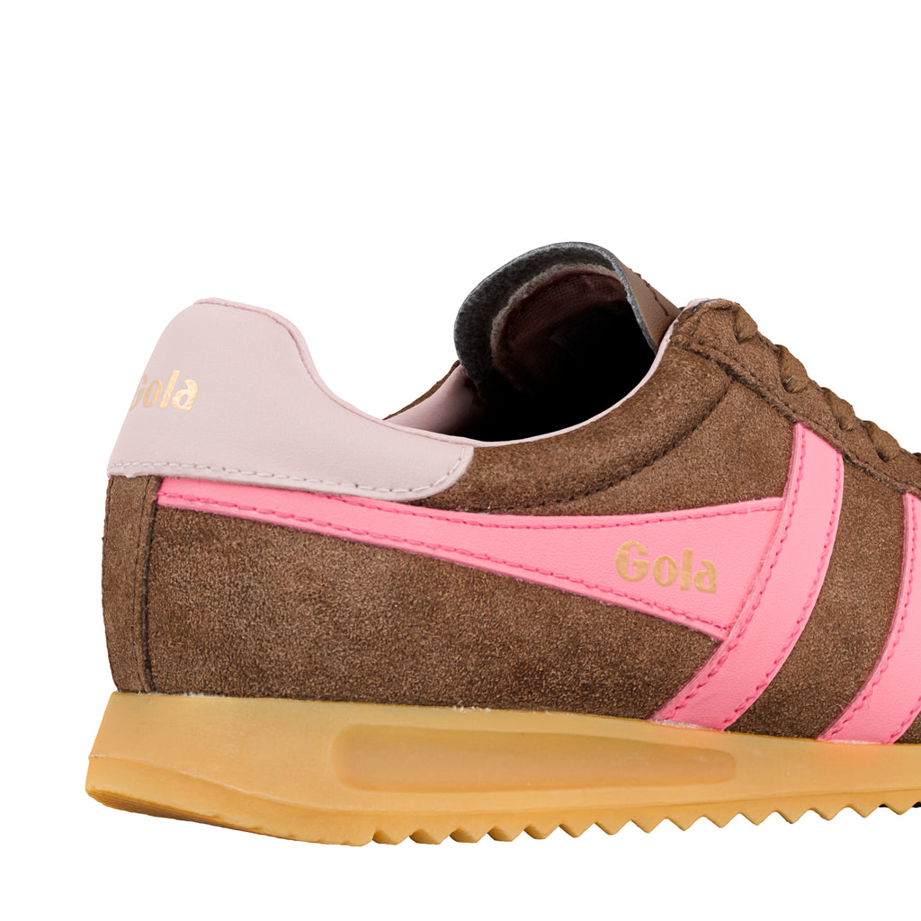 Close up of brown suede trainer with pink side stripes and gum sole