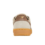 Rear view of a beige and brown suede trainer with a gum rubber sole