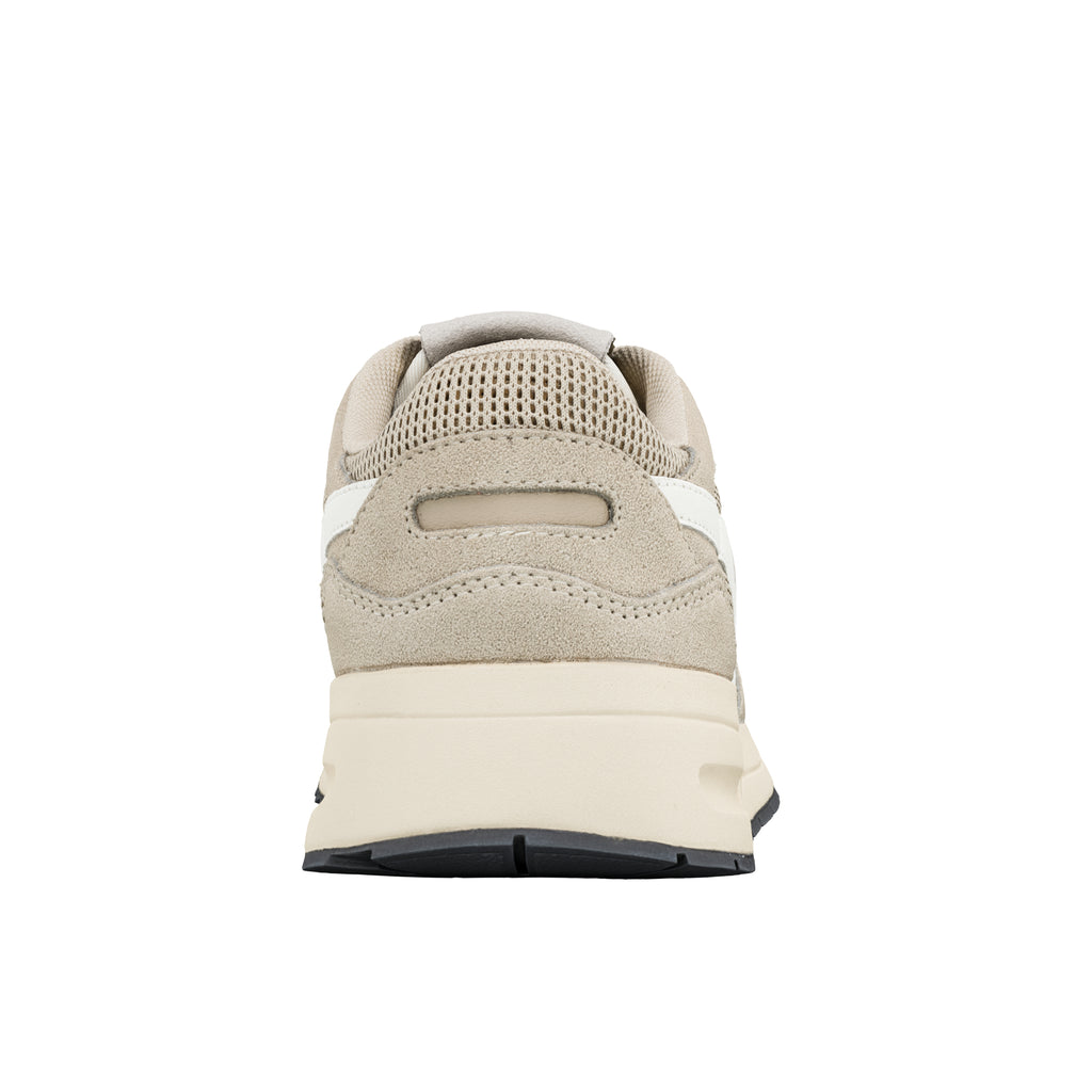 Rear view of a beige suede trainer with a cream midsole and black rubber outsole
