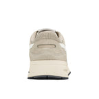 Rear view of a beige suede trainer with a cream midsole and black rubber outsole