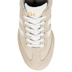Close-up of a Gola trainer in beige with white laces and side stripes