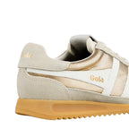 Close-up of a Gola trainer in gold, white, and beige with a gum sole