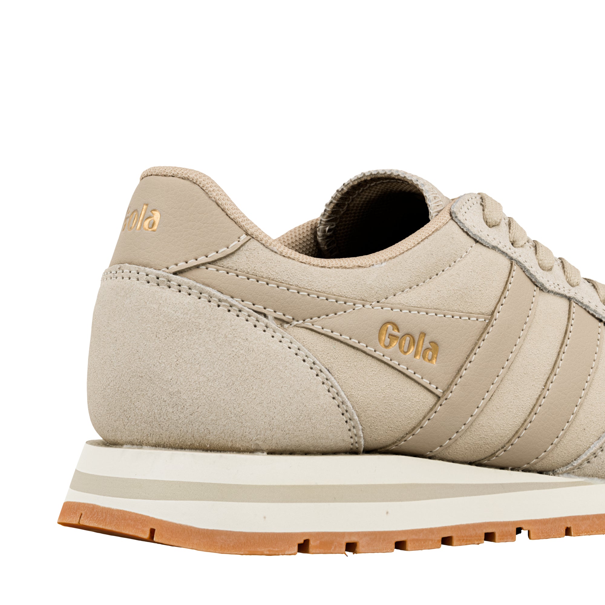 Close up of the heel and side panel of a beige Gola trainer with gold branding