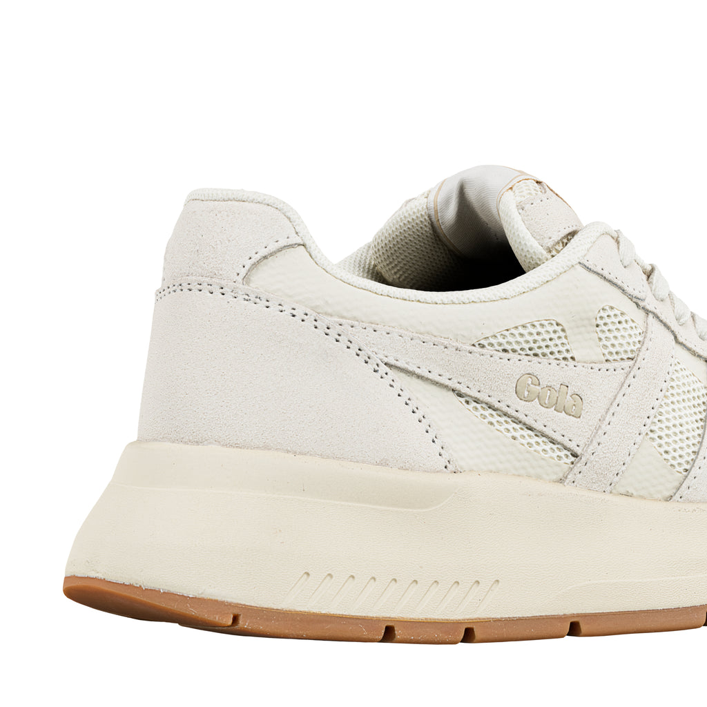 Close up of the heel and side panel of a cream coloured Gola trainer with mesh detailing and a gum rubber sole