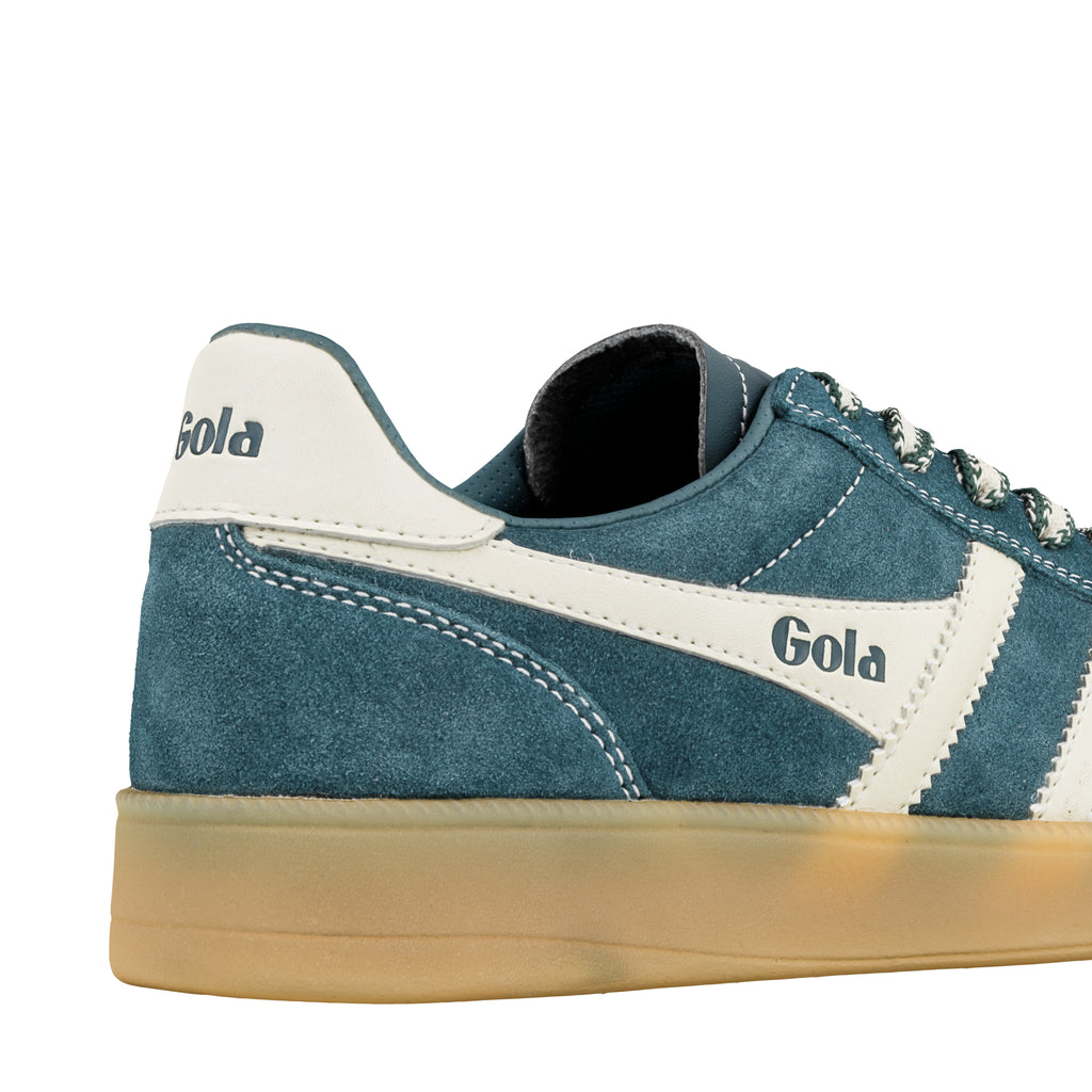 Close up of blue suede trainer with white trim and gum sole
