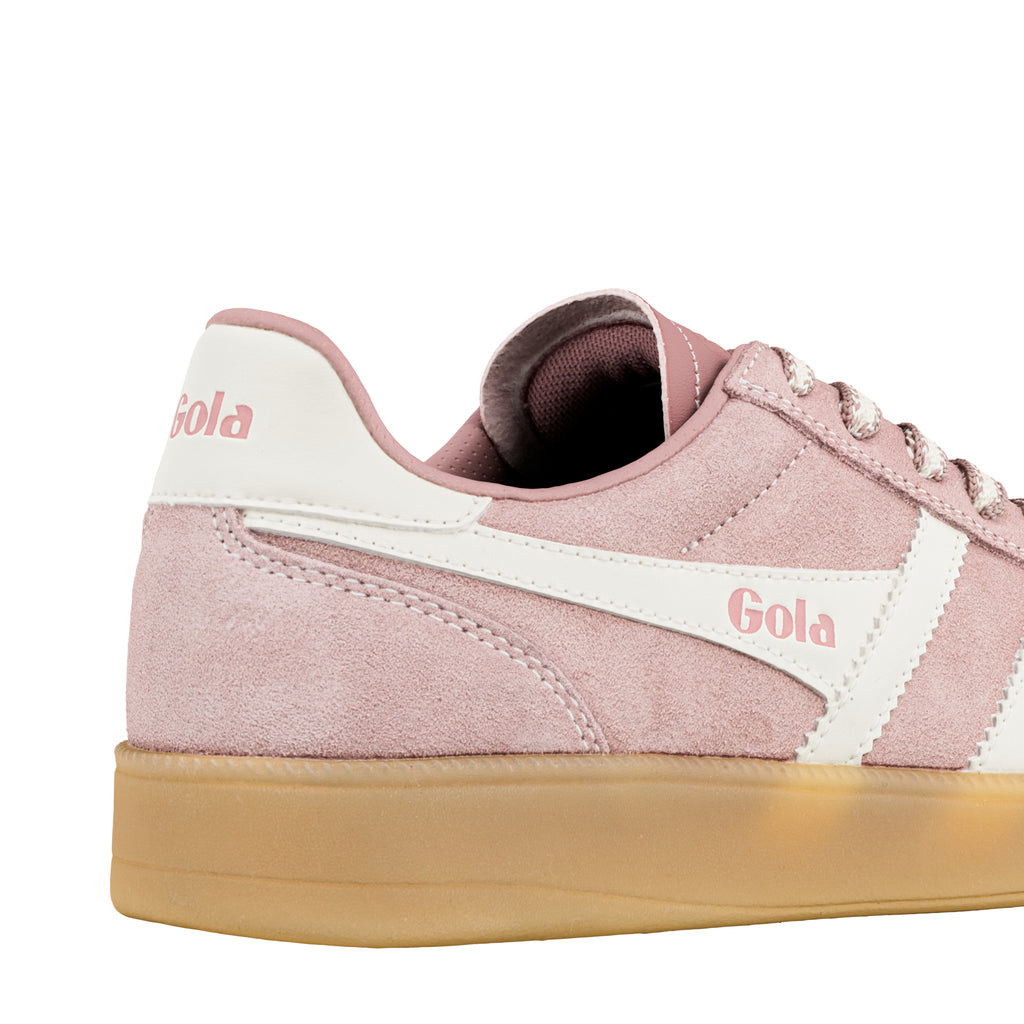 Close up of a pink suede Gola trainer with white side panels and a gum sole
