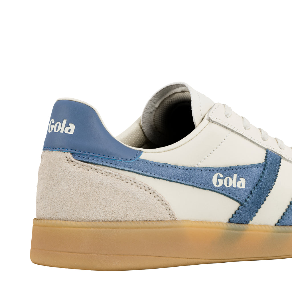 Close up of the heel and side panel of a white and blue Gola trainer with a gum sole