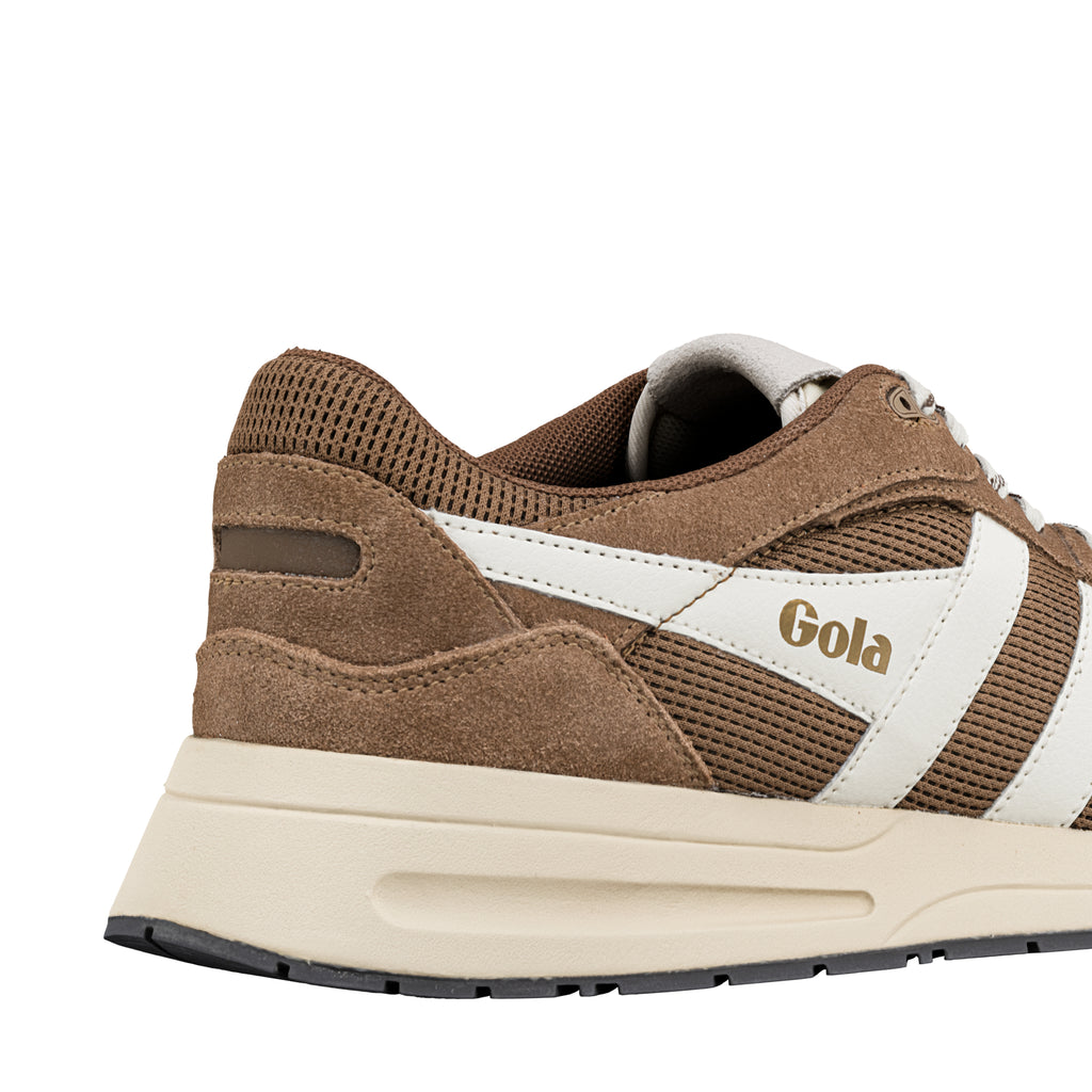 Close up of brown suede and mesh trainer with white side stripes and cream sole