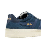 Close up of the heel and side panel of a navy blue suede and leather trainer with gold branding
