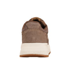 Rear view of a brown suede trainer with a thick white sole and gum rubber base