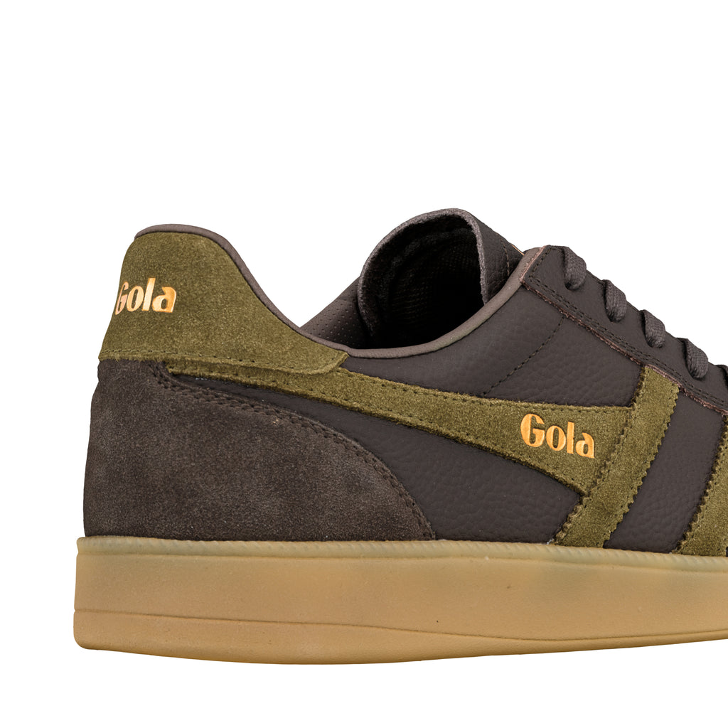 Close up of the heel and side of a dark brown and olive green Gola trainer with a gum sole