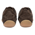 Pair of brown suede trainers with light brown soles, rear view