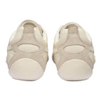 Pair of cream-coloured trainers with suede accents, rear view