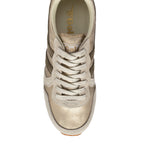 Top-down view of a gold and beige Gola trainer with white laces