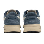 Pair of blue suede trainers with beige soles, rear view