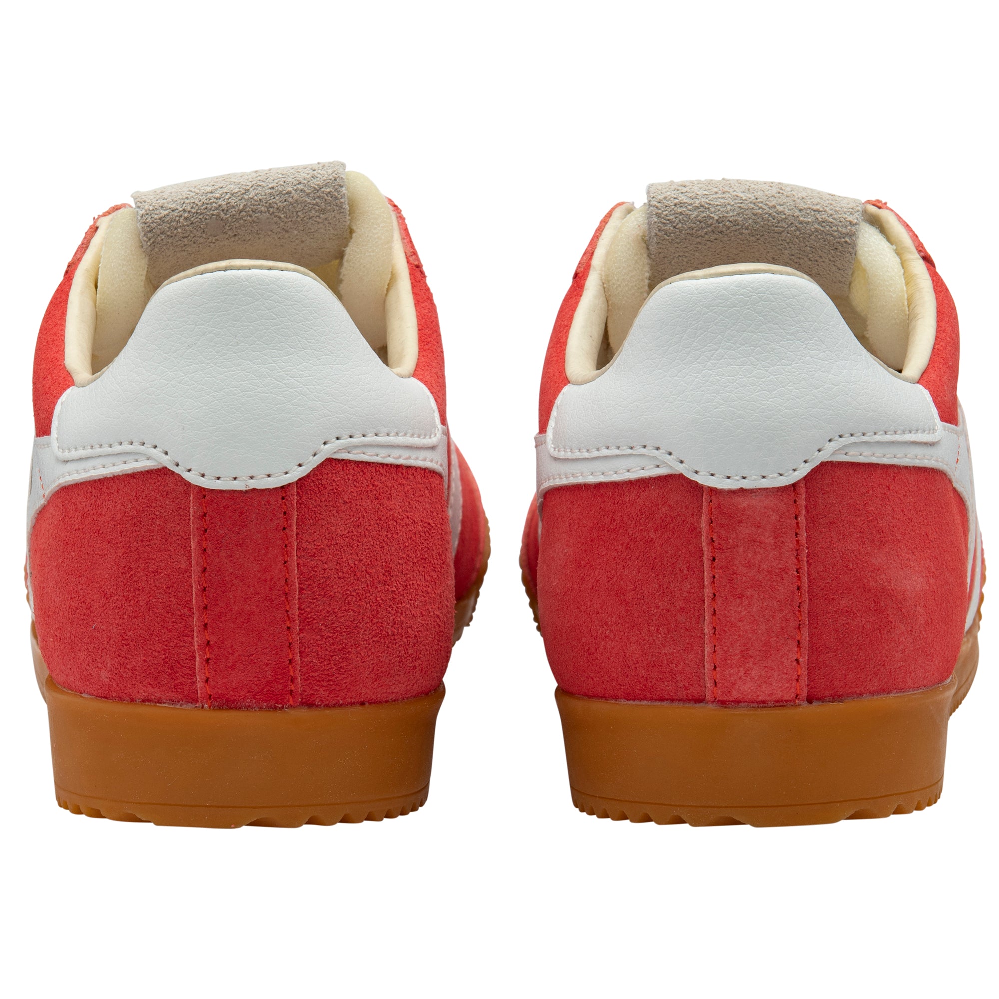 Red trainers with white soles and brown soles on a white background