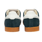 Pair of dark green suede trainers with white leather heel tabs and tan rubber soles, rear view