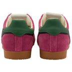 Pair of pink trainers with green accents on a white background