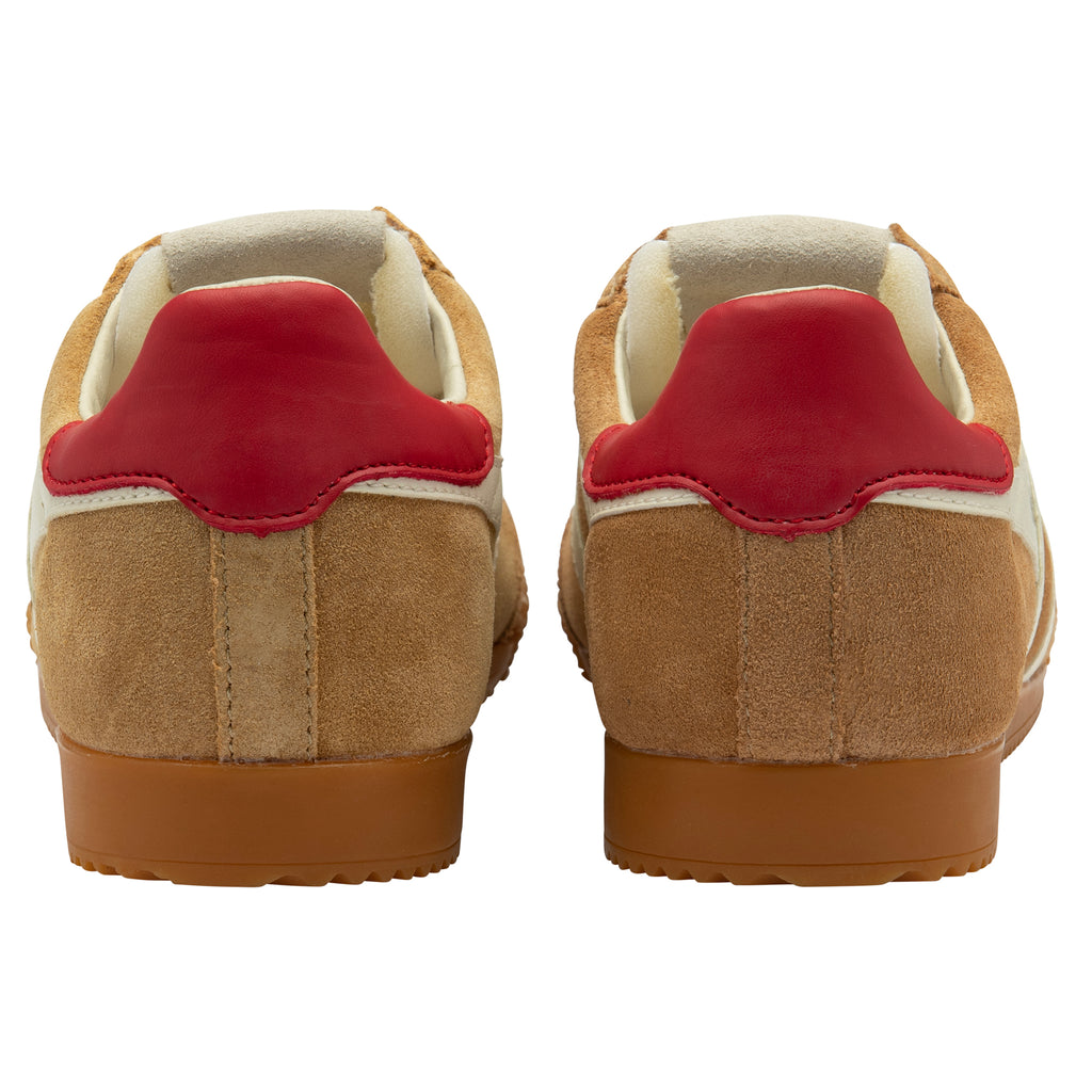 Pair of tan trainers with red heel on a white background