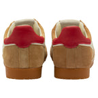 Pair of tan trainers with red heel on a white background