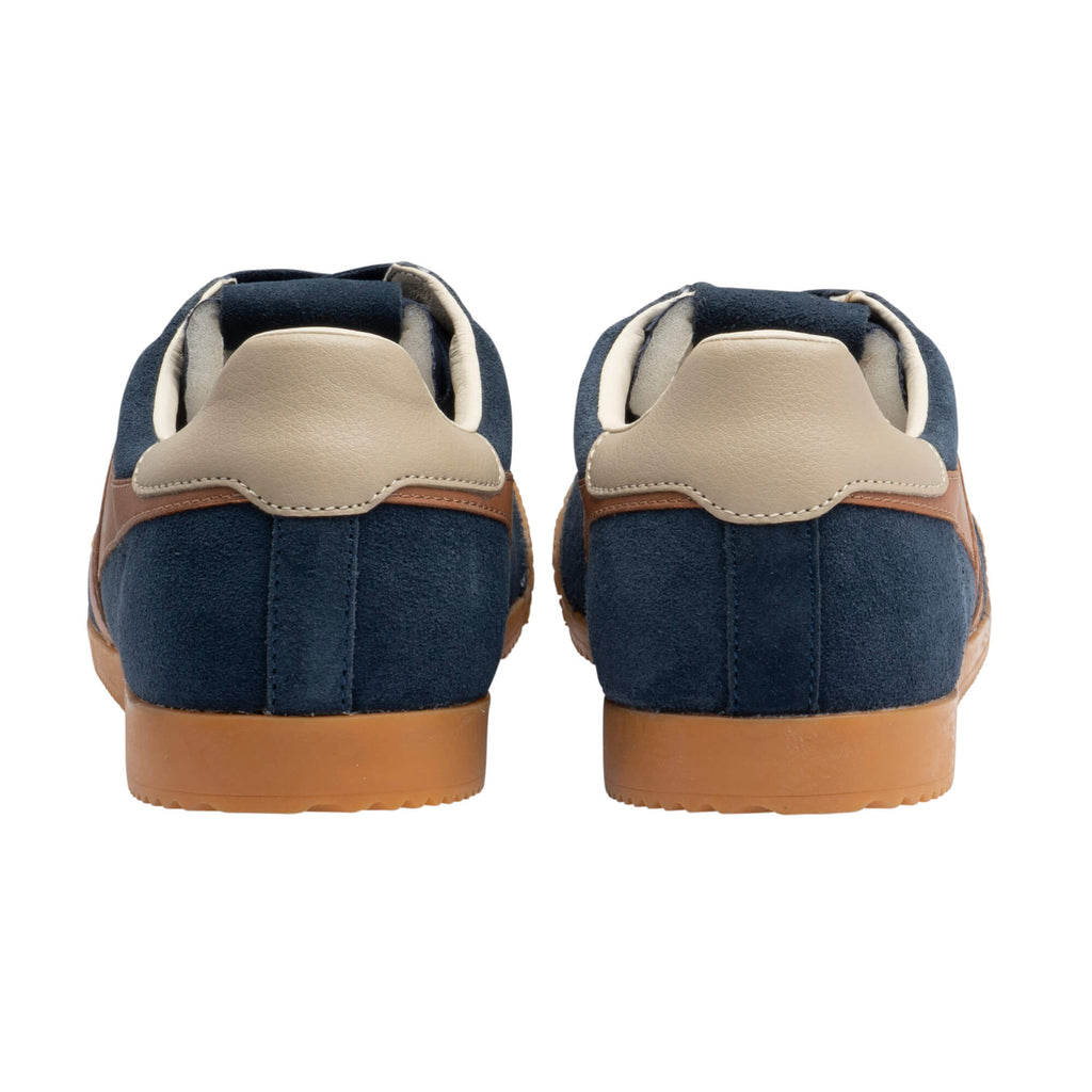 Rear view of two navy blue suede trainers with tan leather accents and gum soles