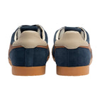 Rear view of two navy blue suede trainers with tan leather accents and gum soles