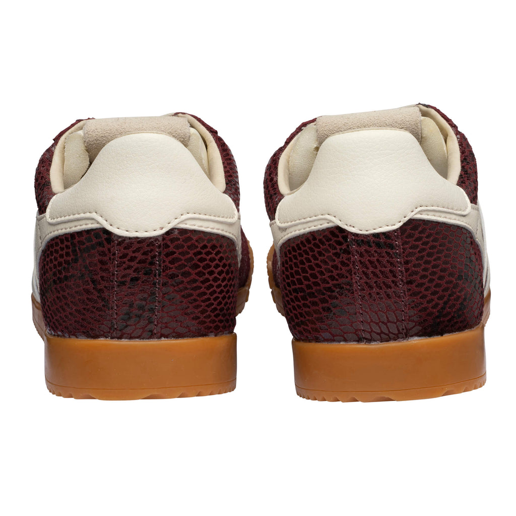 Pair of burgundy trainers with a snakeskin pattern and cream heel tab, rear view