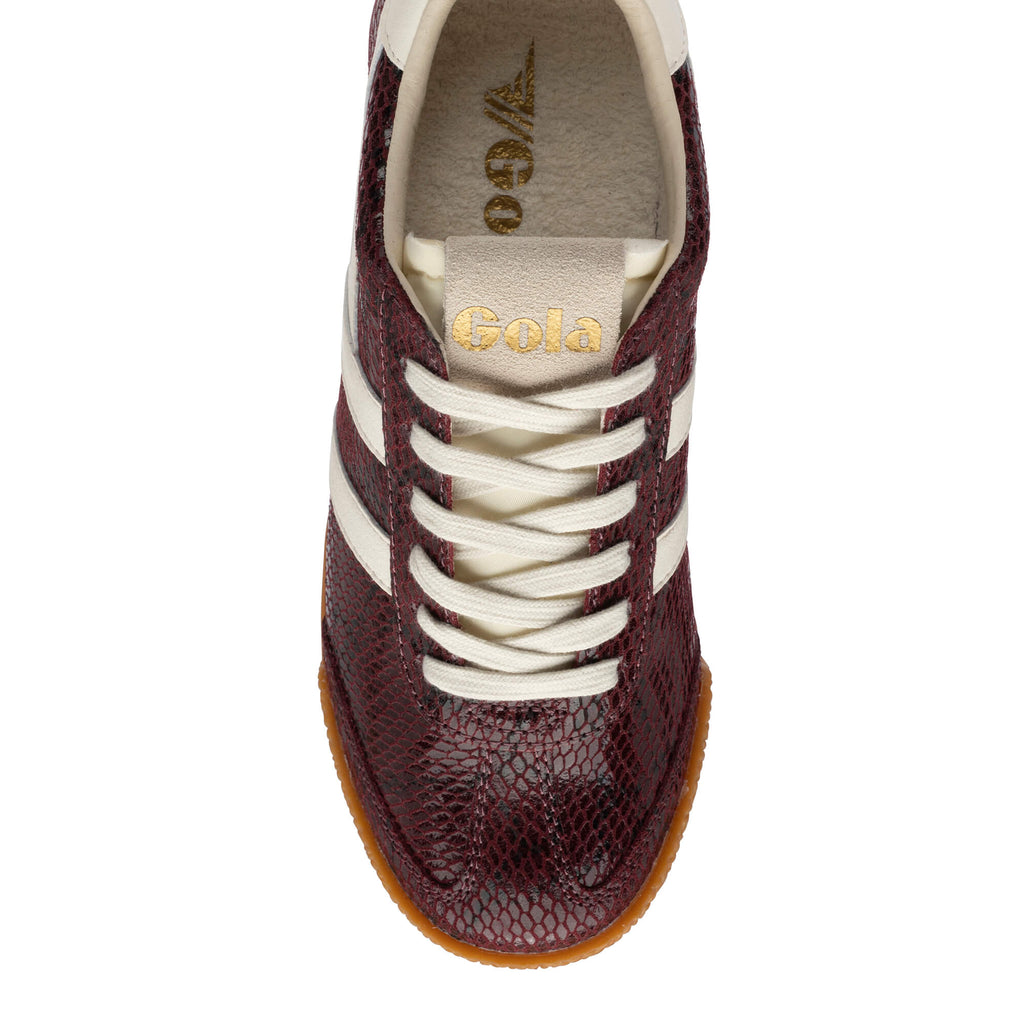 Top-down view of a Gola trainer in burgundy with a snakeskin pattern, white laces, and a gum sole