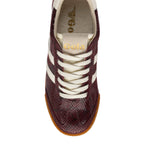 Top-down view of a Gola trainer in burgundy with a snakeskin pattern, white laces, and a gum sole