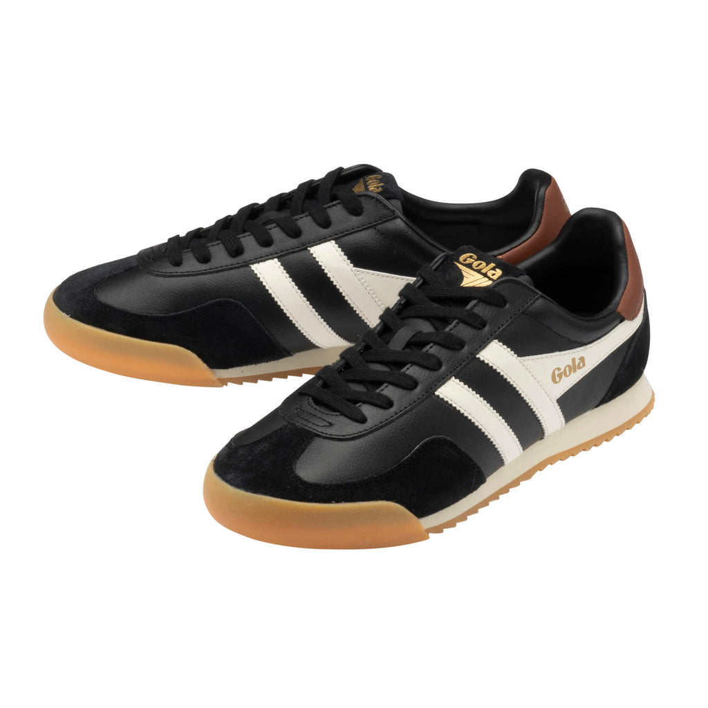 Pair of Gola Harrier trainers in black with white stripes, brown heel trim, and gum sole