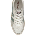 Top-down view of a Gola trainer in off-white with green stripes and brown branding