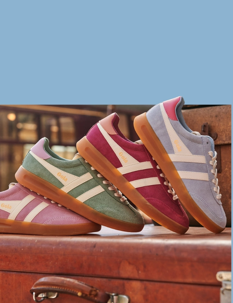 Four pairs of Gola trainers in pink, green, maroon, and blue, with white stripes and gum soles