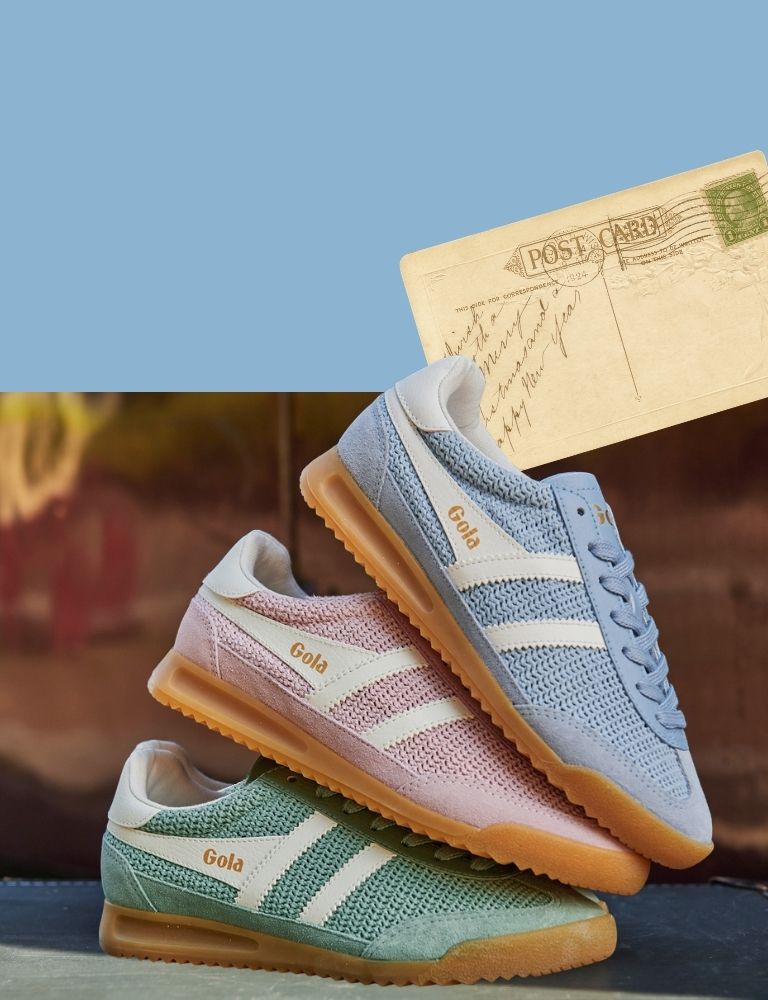 Three Gola trainers in blue, pink, and green, with a vintage postcard in the background