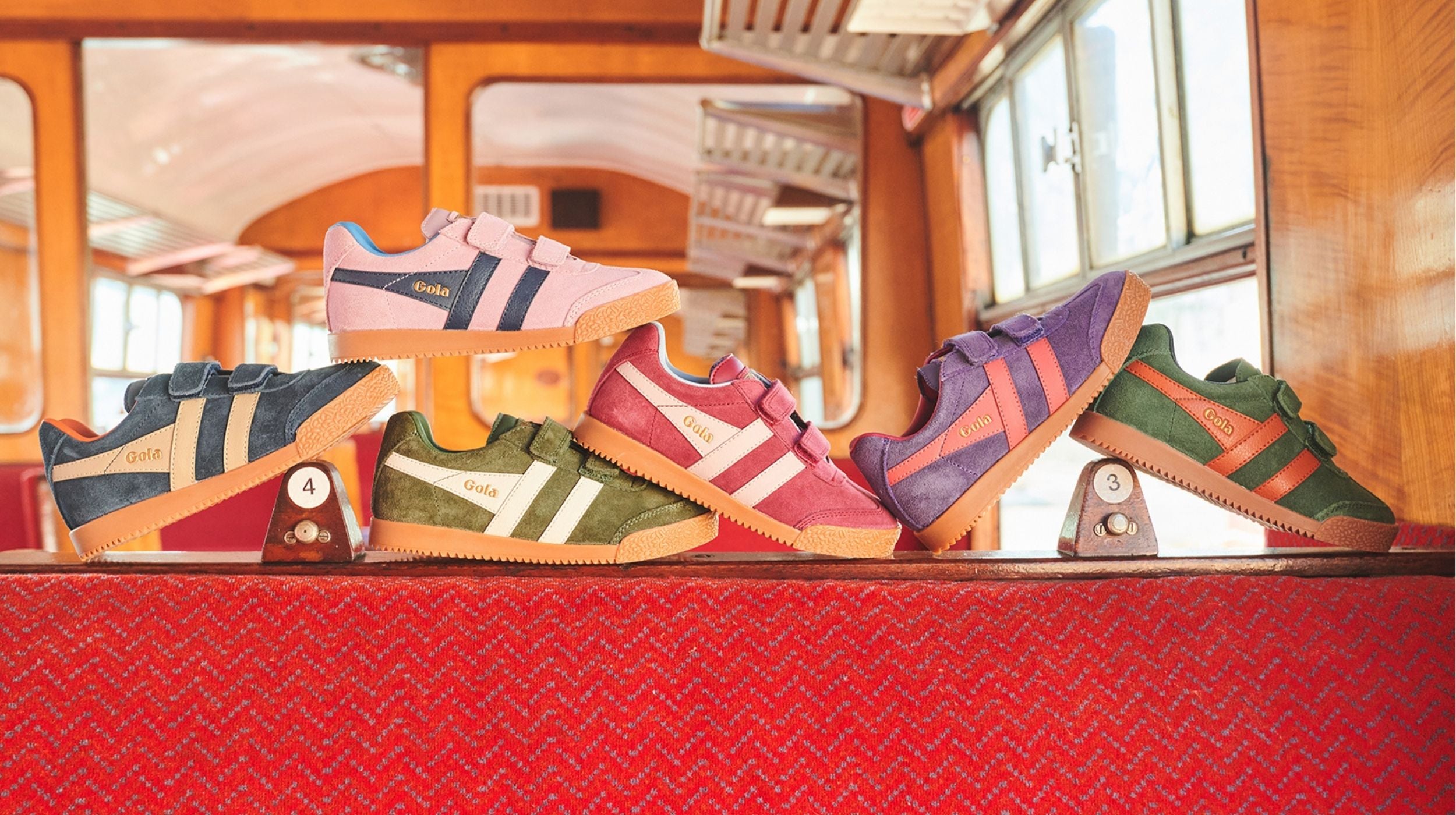 Colourful trainers on a red bench seat with a blurred background