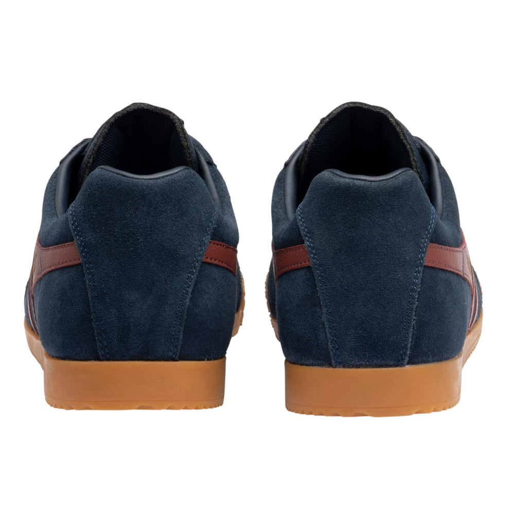 Rear view of two navy blue suede trainers with brown stripes and gum soles