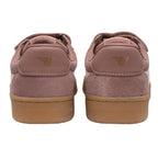 Pair of pink suede trainers with brown soles, rear view