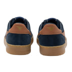 Pair of navy blue suede trainers with tan leather accents and gum soles, rear view