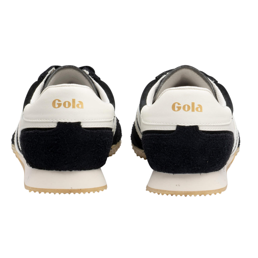 Rear view of black and white Gola trainers with gold Gola branding on the heel