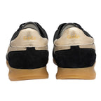 Rear view of black and gold trainers with Gola branding on the heel