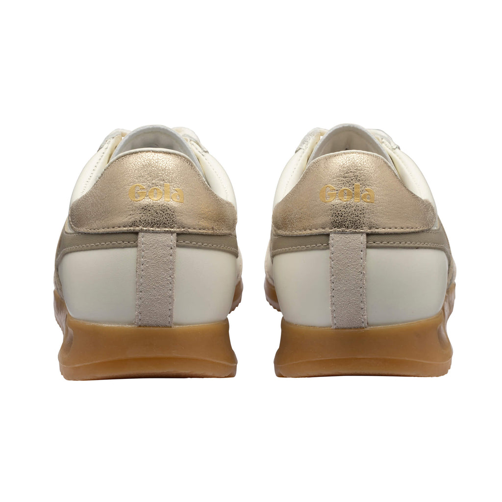 Rear view of two Gola trainers with white uppers, gold heel tabs, and gum soles