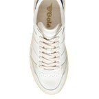 Overhead view of a white Gola trainer with cream laces and a gold Gola logo on the insole